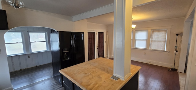 kitchen featuring ornamental molding, dark hardwood / wood-style flooring, and black fridge with ice dispenser