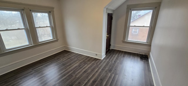 spare room with dark wood-type flooring and a wealth of natural light