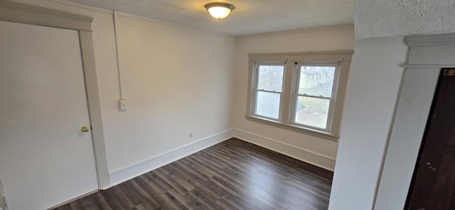 spare room with dark wood-type flooring and a textured ceiling