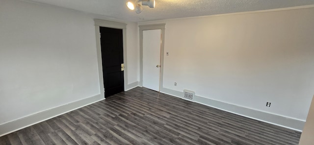 empty room featuring dark wood-type flooring and a textured ceiling