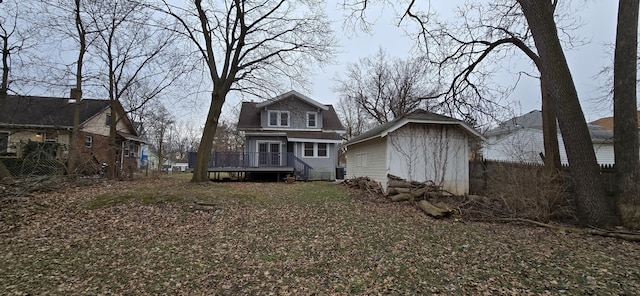 back of property featuring a storage shed and a deck