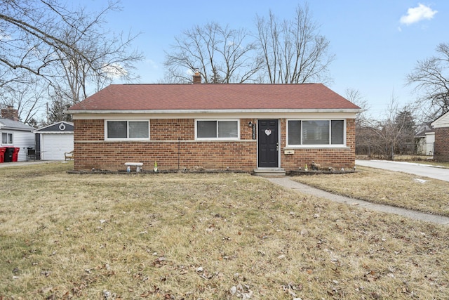 view of front of home featuring an outbuilding, a garage, and a front yard