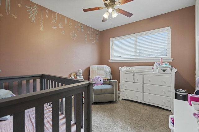 bedroom featuring carpet floors, a nursery area, and ceiling fan