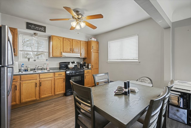 kitchen with sink, light hardwood / wood-style flooring, stainless steel refrigerator, ceiling fan, and gas stove