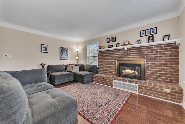 living room featuring hardwood / wood-style flooring and a brick fireplace