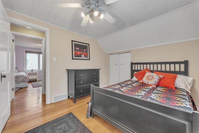 bedroom with ceiling fan, vaulted ceiling, and light wood-type flooring