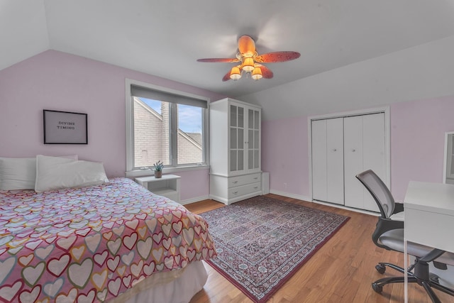 bedroom featuring ceiling fan, lofted ceiling, light wood-type flooring, and a closet