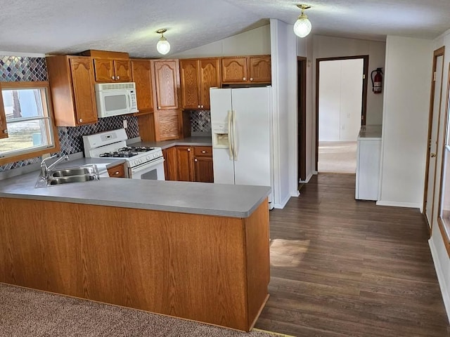 2054 Woodside Dr, Caro, MI 48723 - kitchen featuring white appliances, a sink, brown cabinetry, lofted ceiling, and a peninsula