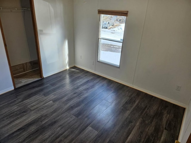 2054 Woodside Dr, Caro, MI 48723 - unfurnished bedroom featuring dark wood finished floors, baseboards, and a closet