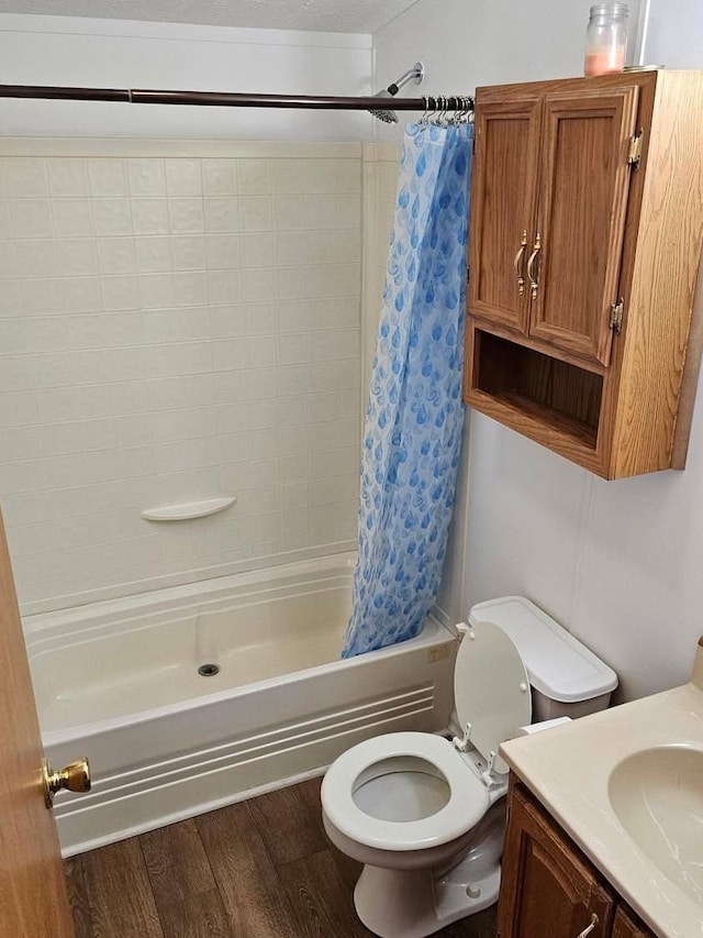 2054 Woodside Dr, Caro, MI 48723 - full bathroom featuring toilet, wood finished floors, vanity, and shower / tub combo