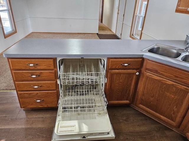 2054 Woodside Dr, Caro, MI 48723 - kitchen featuring a sink, dishwashing machine, dark wood-style floors, and brown cabinetry