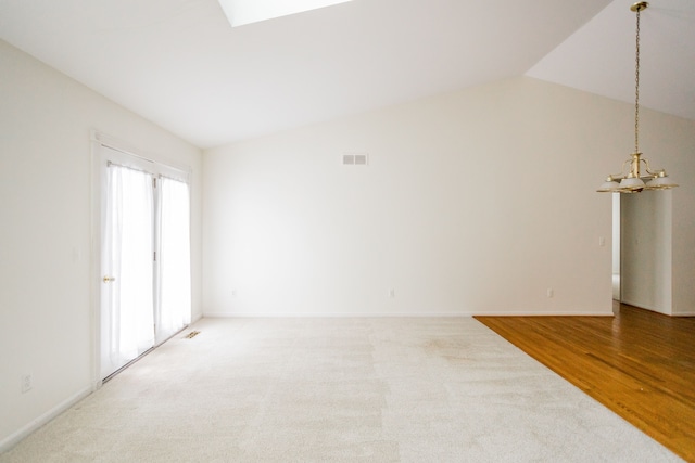 unfurnished room featuring lofted ceiling and hardwood / wood-style floors