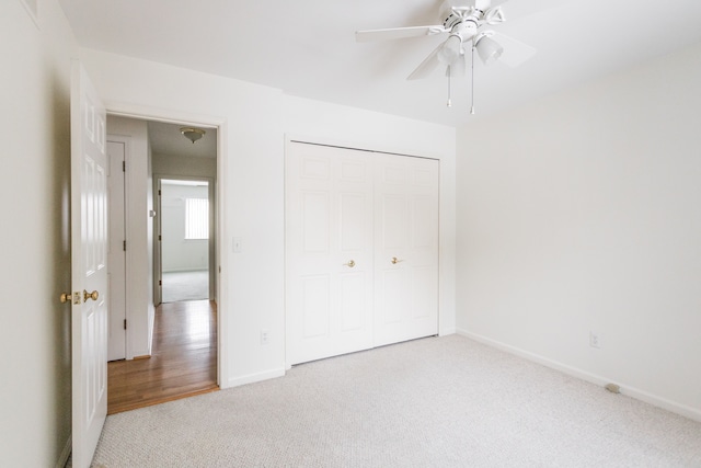 unfurnished bedroom featuring light carpet, ceiling fan, and a closet