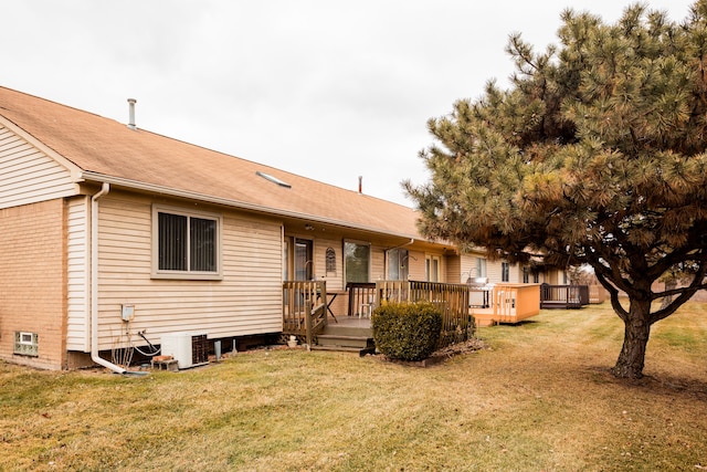 rear view of property with a wooden deck, central AC, and a lawn