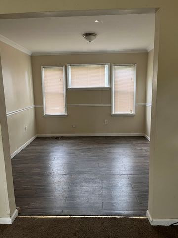 unfurnished room with dark wood-type flooring, a wealth of natural light, and ornamental molding