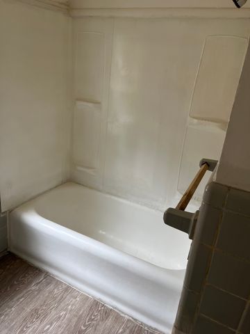 bathroom with hardwood / wood-style flooring and tub / shower combination