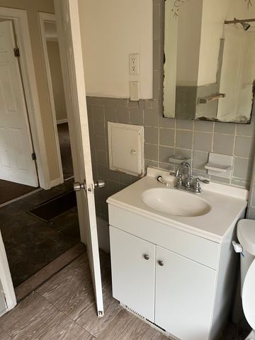 bathroom with vanity, tile walls, and toilet