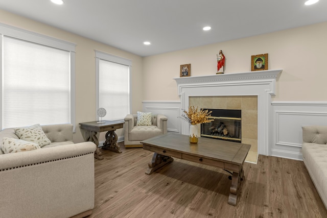 living room featuring a tile fireplace and light hardwood / wood-style flooring