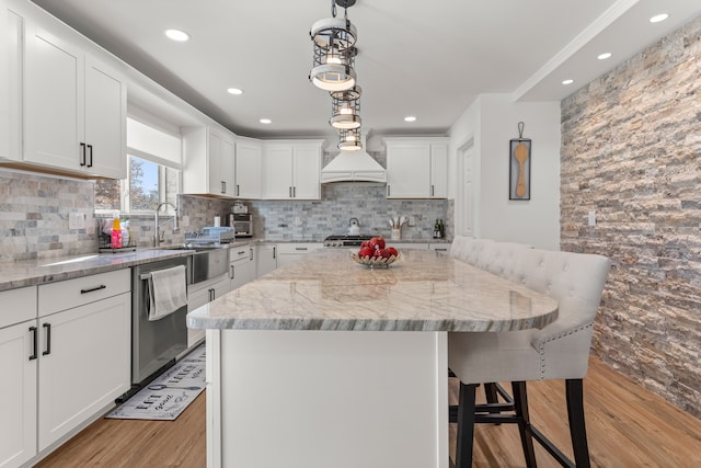 kitchen with a center island, stainless steel dishwasher, and white cabinets