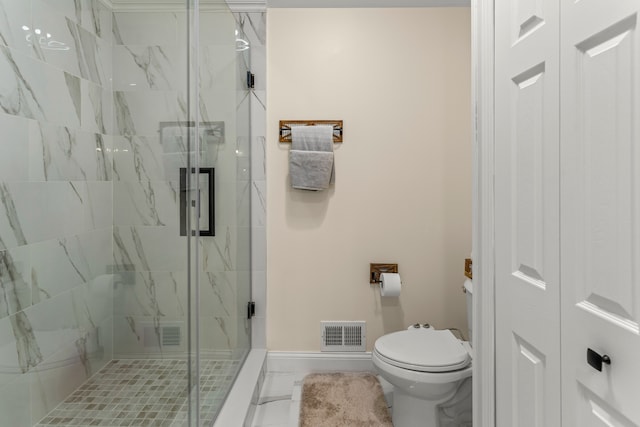 bathroom featuring a shower with door and toilet