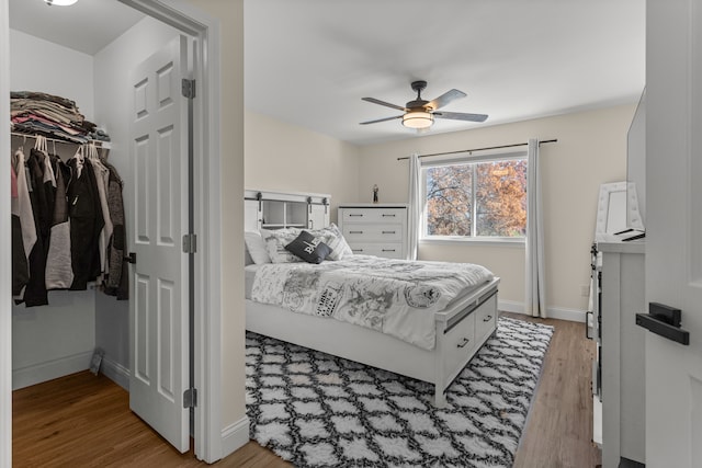 bedroom with ceiling fan, light hardwood / wood-style floors, and a closet