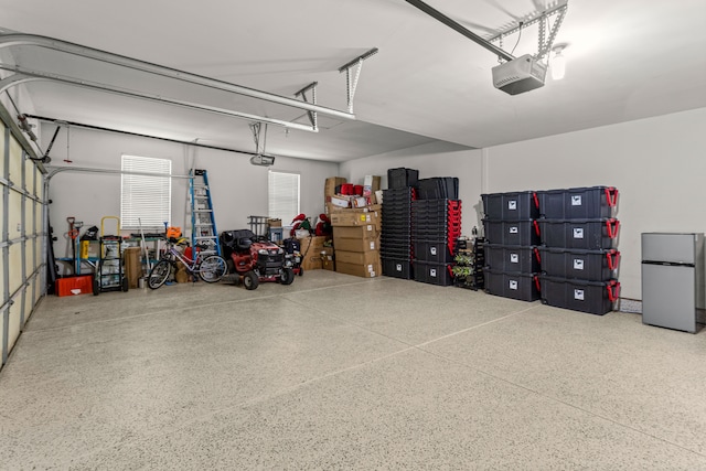 garage featuring a garage door opener and stainless steel refrigerator