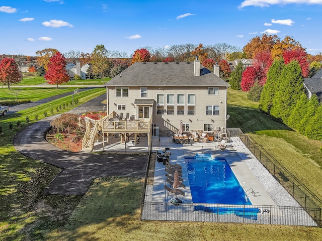 back of property with a yard, a patio, and a swimming pool side deck