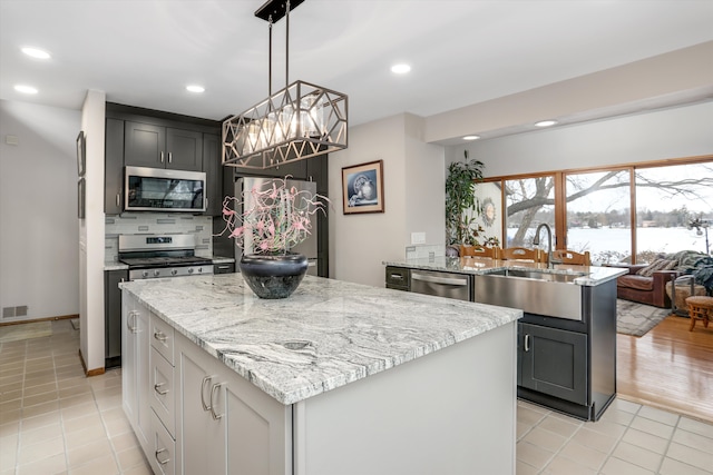 kitchen featuring sink, hanging light fixtures, a center island, and appliances with stainless steel finishes