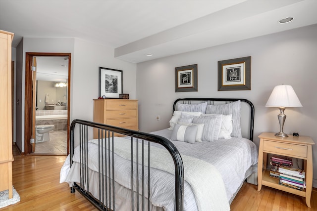 bedroom featuring connected bathroom and light wood-type flooring