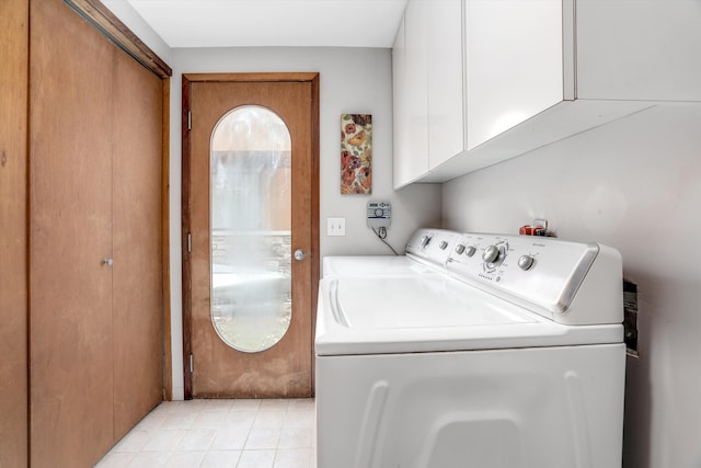 washroom featuring light tile patterned flooring, cabinets, and washing machine and dryer