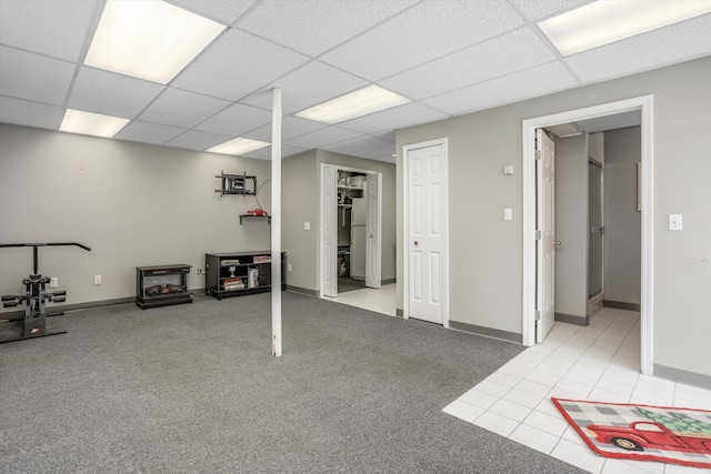 basement featuring a paneled ceiling and light tile patterned floors