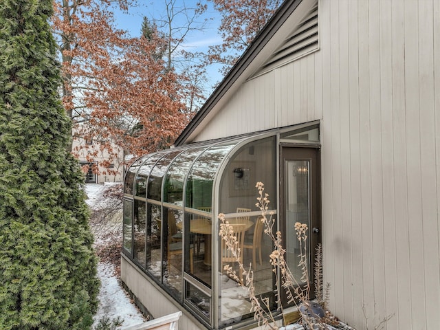 snow covered property with a sunroom