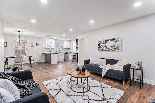 living room featuring dark wood-type flooring and a notable chandelier