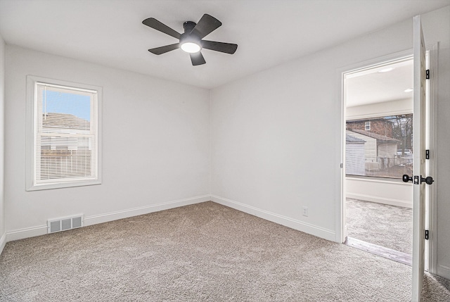 carpeted spare room featuring ceiling fan