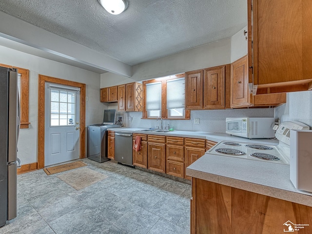 kitchen with appliances with stainless steel finishes, sink, and a textured ceiling