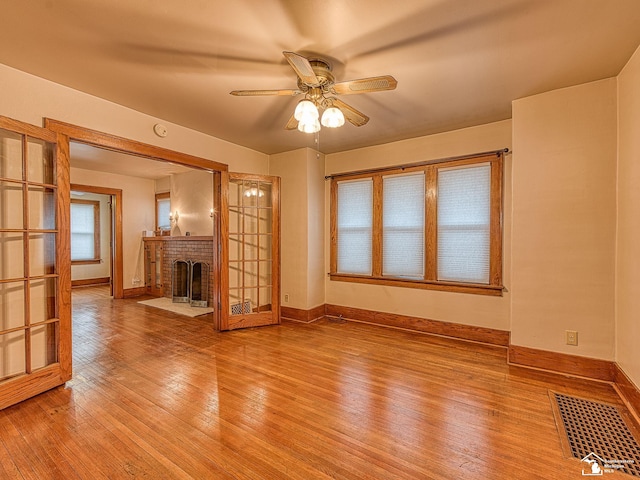 unfurnished living room featuring hardwood / wood-style floors, a fireplace, and ceiling fan