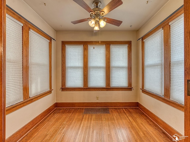 unfurnished sunroom with ceiling fan