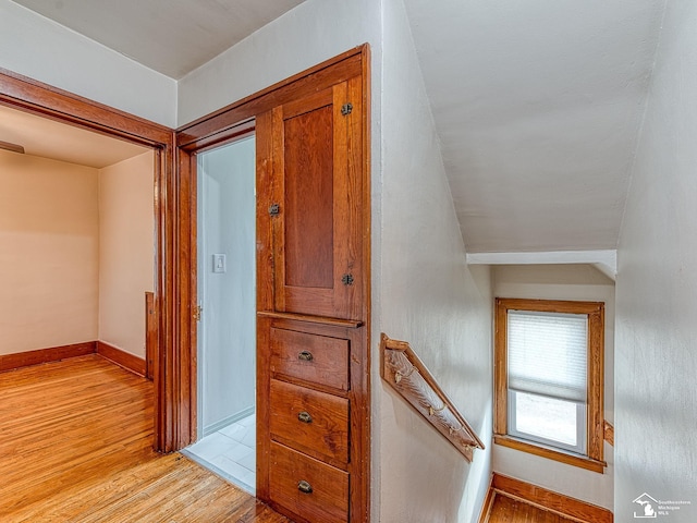 corridor featuring vaulted ceiling and light wood-type flooring