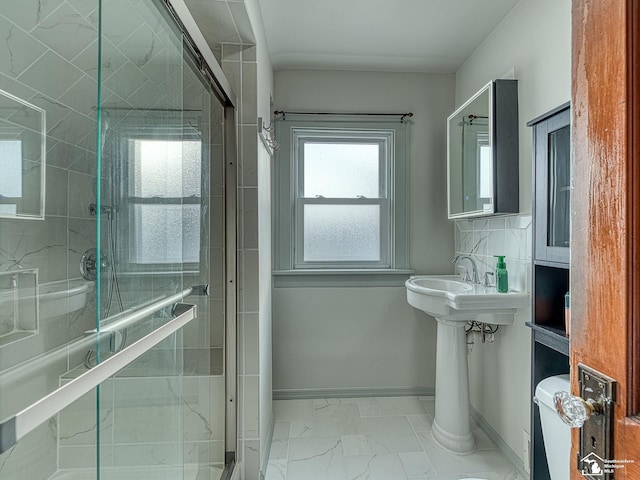 bathroom featuring sink, backsplash, and a shower with shower door