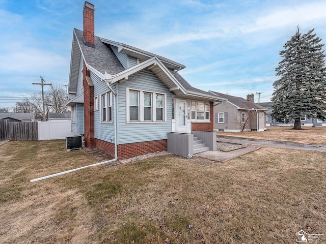 view of front of property featuring a front yard and cooling unit