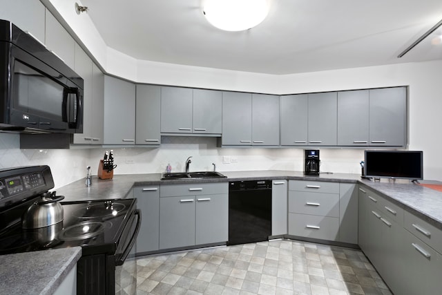 kitchen featuring a sink, backsplash, black appliances, and gray cabinets