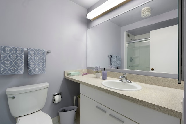 bathroom with vanity, toilet, and a shower with door