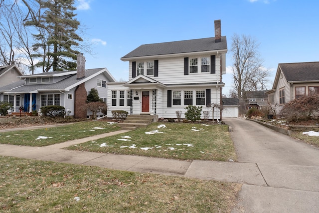 view of front of home with a garage, an outdoor structure, and a front yard