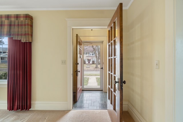 doorway to outside with crown molding and carpet