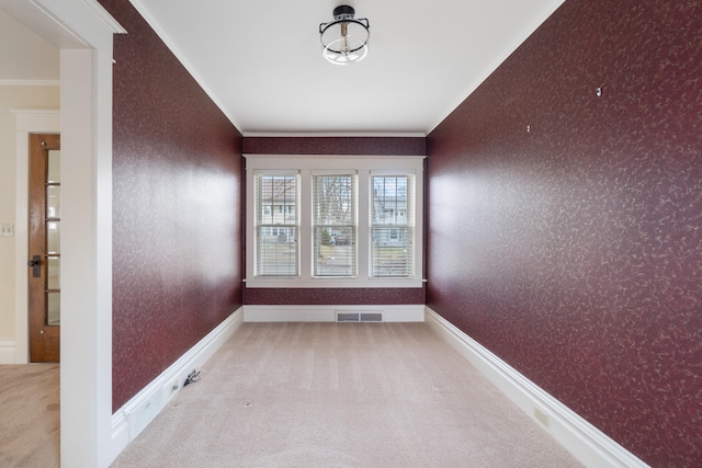 unfurnished room with crown molding and light carpet