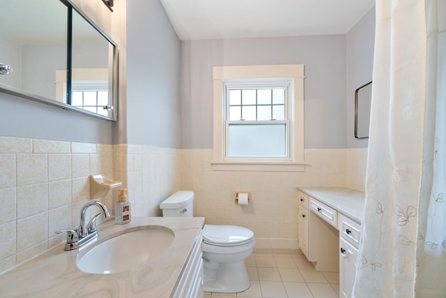 bathroom with vanity, toilet, tile patterned flooring, and tile walls