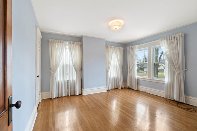 spare room with crown molding and light hardwood / wood-style flooring