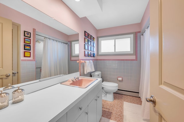 bathroom featuring tile patterned floors, toilet, tile walls, baseboard heating, and vanity