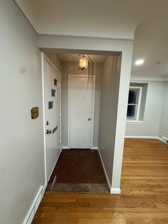 corridor with wood-type flooring