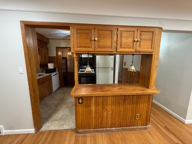 kitchen with fridge, white dishwasher, oven, and light wood-type flooring